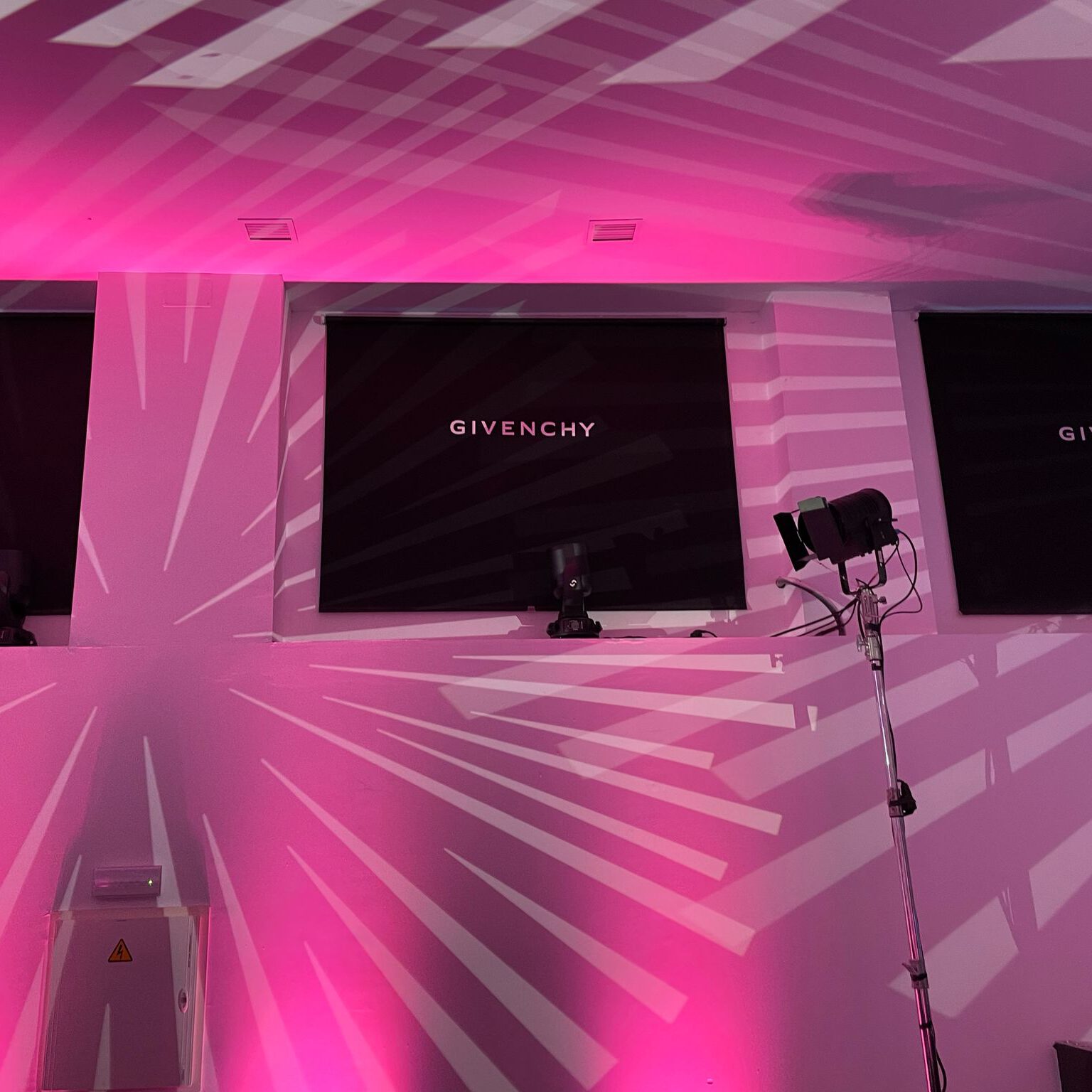 Montaje del espacio de Givenchy en evento de Sephora, con iluminación rosa y proyecciones creativas para reforzar la identidad de la marca.